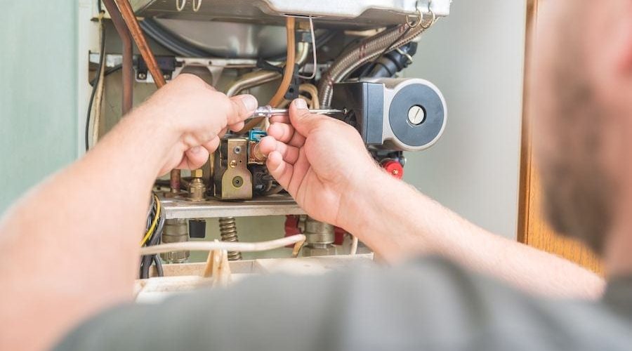 Image of someone working on a furnace. How Do I Know When I Need a New Furnace?