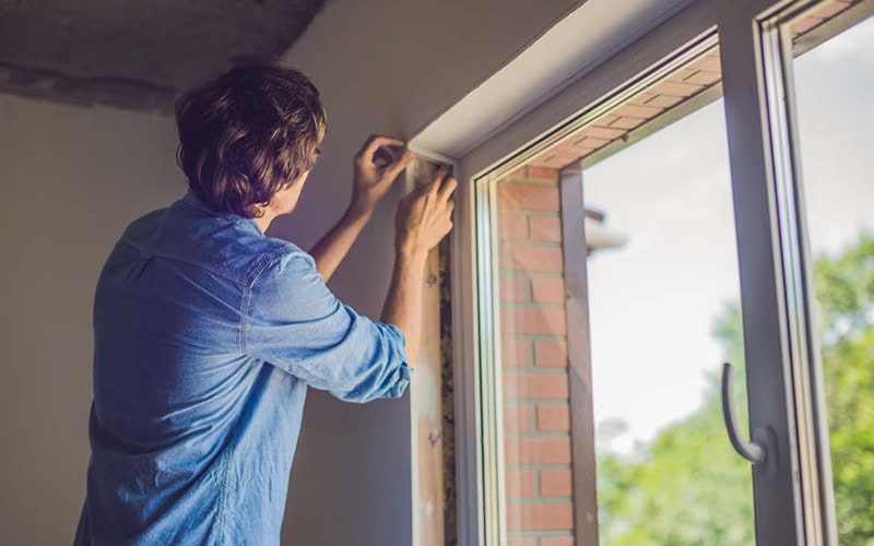 man insulating windows