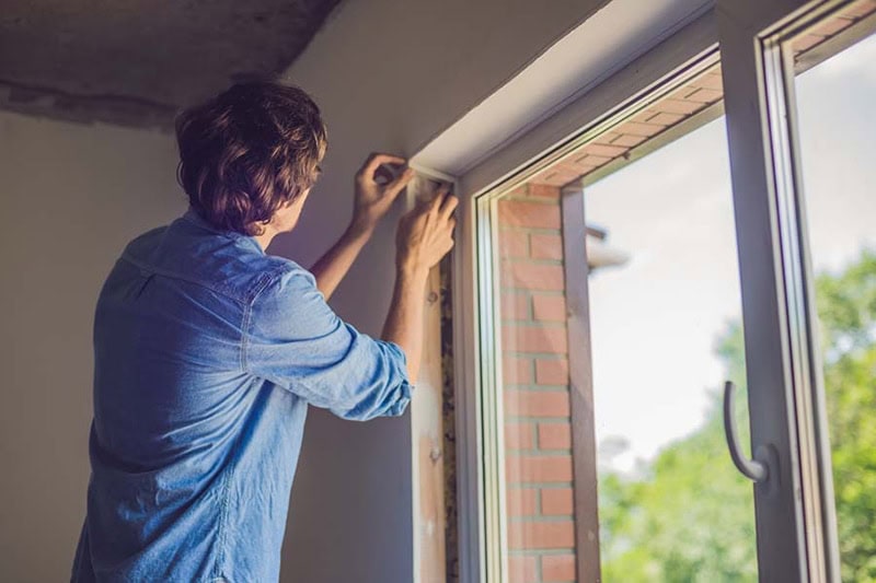 man insulating windows
