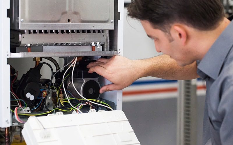 HVAC technician performing maintenance on a heat pump.
