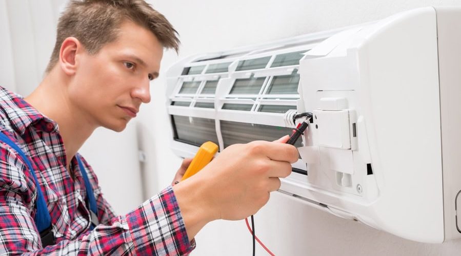 Male Technician Examining Air Conditioner With Multimeter. What You Need to Know for an HVAC Emergency