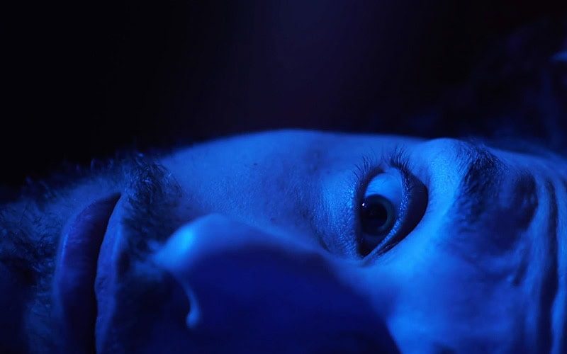 A close-up of a man lying awake in bed | Video - Is Your AC Making Scary Noises? | Call Us Today