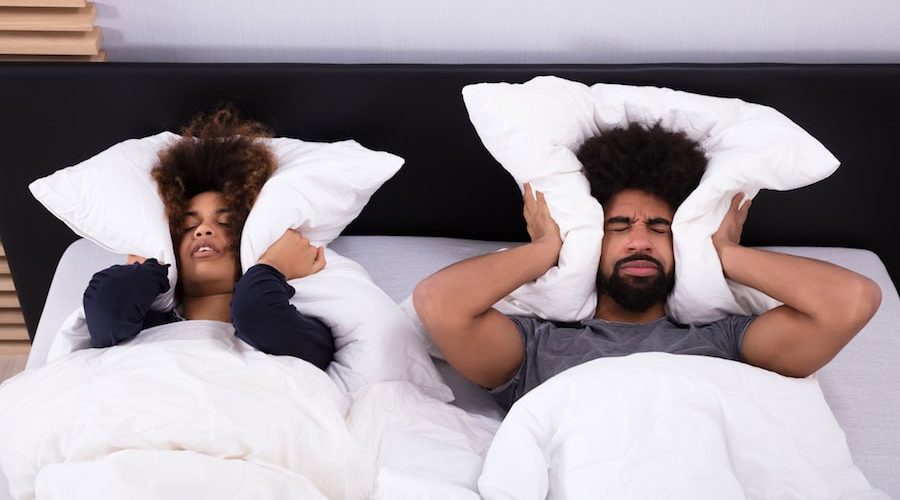 couple covering ears|man in bed