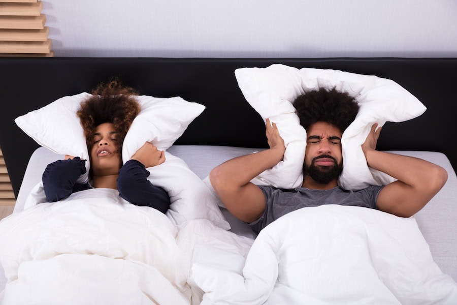 couple covering ears|man in bed