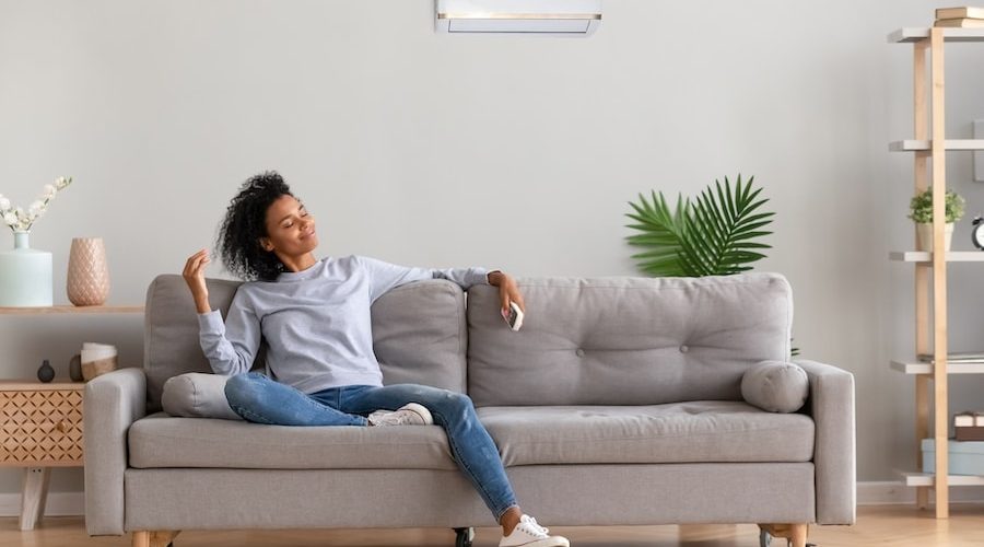 African young relaxed woman sitting on couch breathing fresh air What Accessories Can Help With My Indoor Air Quality?