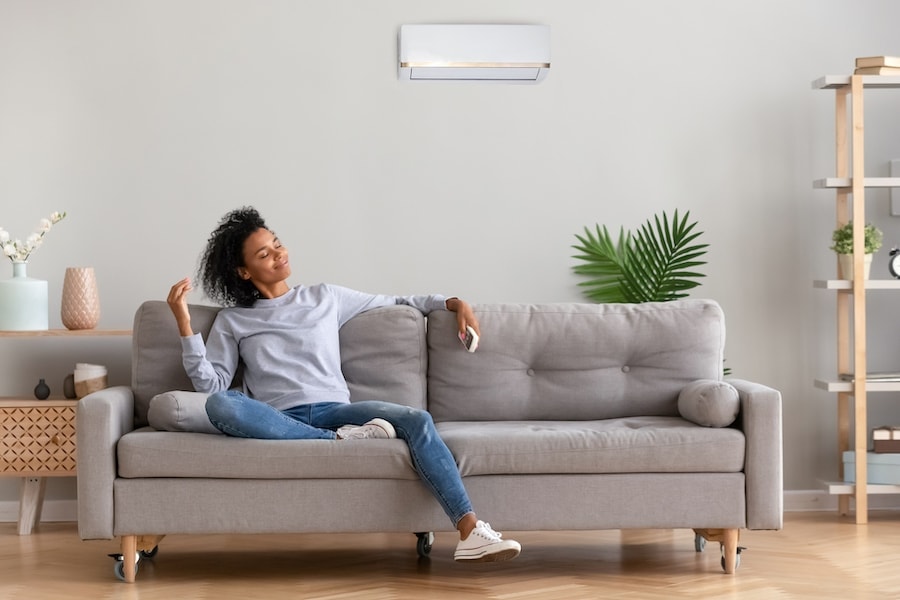 African young relaxed woman sitting on couch breathing fresh air What Accessories Can Help With My Indoor Air Quality?