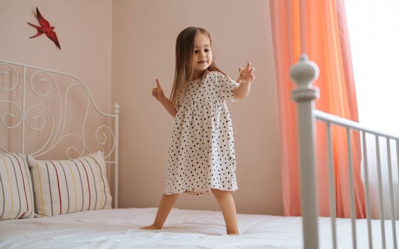 What You Should Know About Air Handlers. Happy funny little child girl in motion jumping on bed alone flying in air feeling joy, cheerful cute active kid having fun playing laughing in bedroom after waking up, good morning children concept.