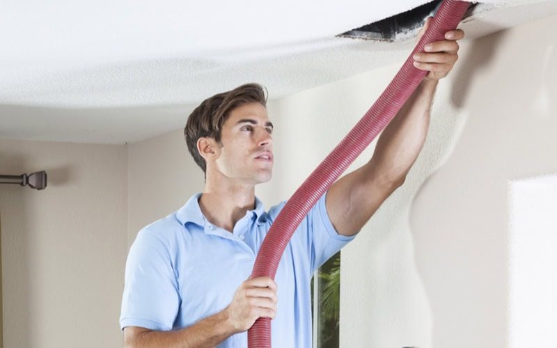 Man cleaning air ducts in home.