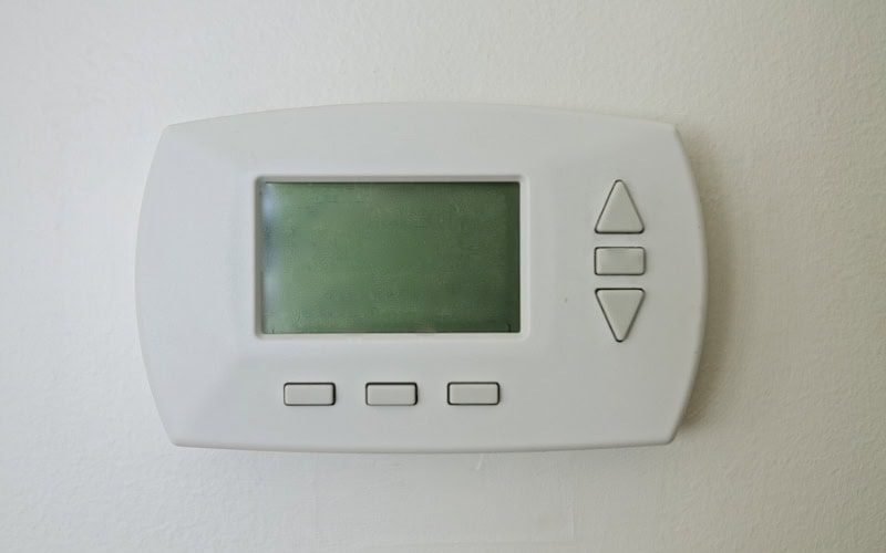 Why Is My Thermostat Blank? Photo of a digital thermostat mounted on a wall with a blank screen.