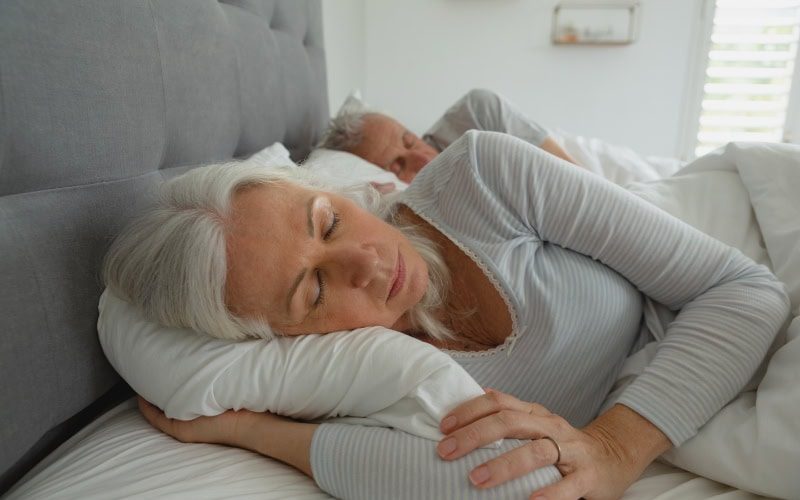 Elderly woman asleep in bed.