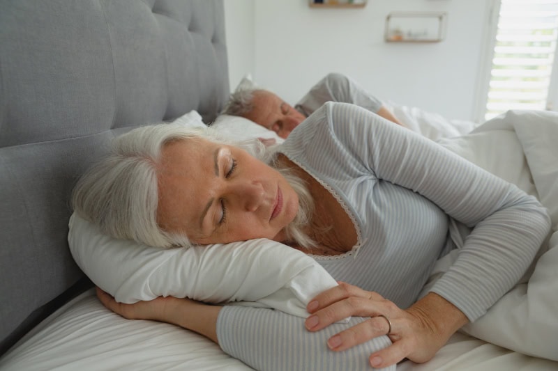 Elderly woman asleep in bed.