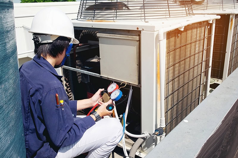 A technician working on a commercial air conditioner.
